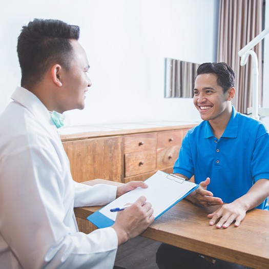 dentist talking to patient about cost of dental implants