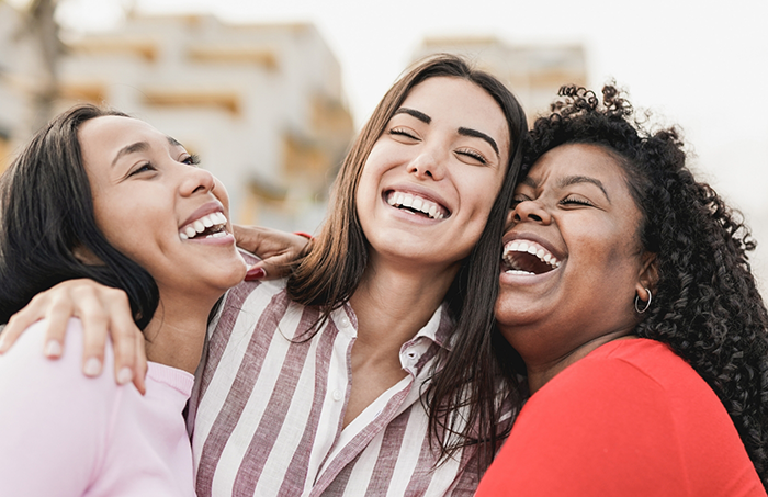 Three women hugging each other and laughing