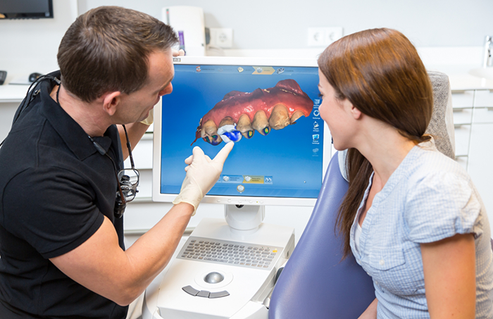 Dentist showing patient scan of teeth on monitor