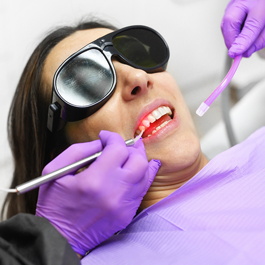 Woman with sunglasses having smile treated with soft tissue laser