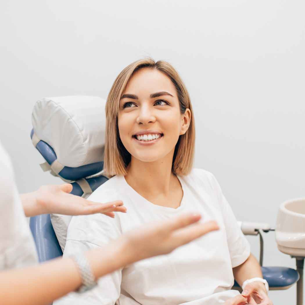 Female patient smiling and looking up at dentist