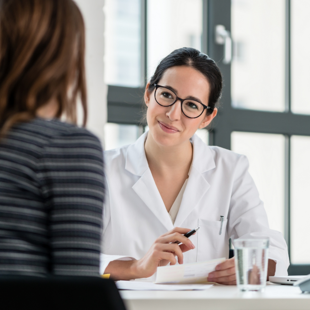 Dental team member smiling at patient over desk