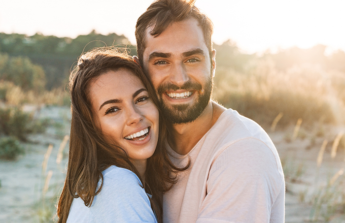 Man and woman hugging and smiling outdoors