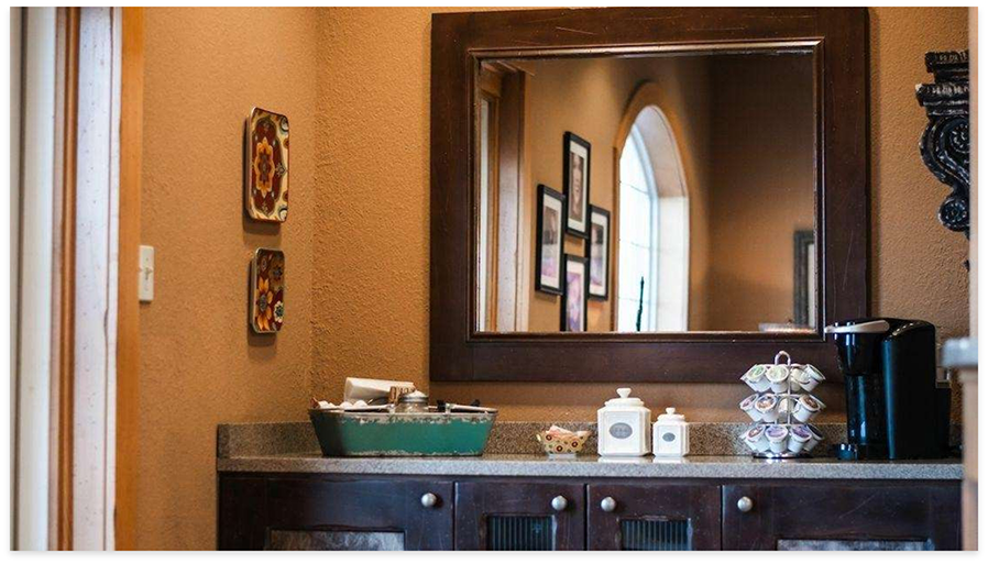 Bathroom with mirror and multiple objects on counter