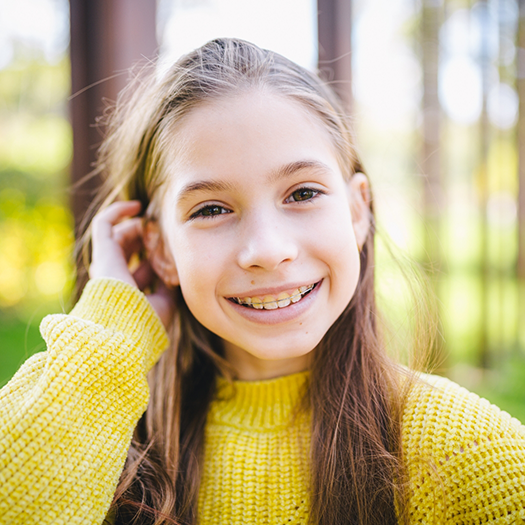 Little girl with braces and yellow sweater