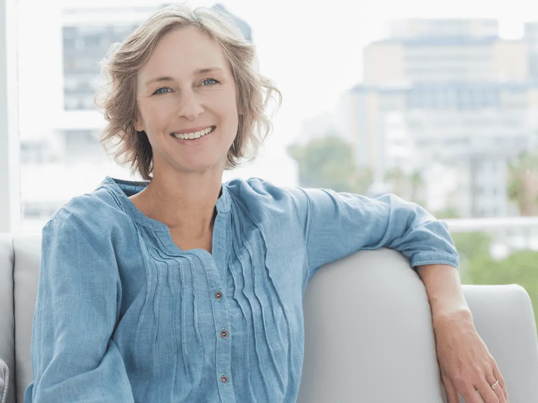 Woman in light blue shirt sitting on couch