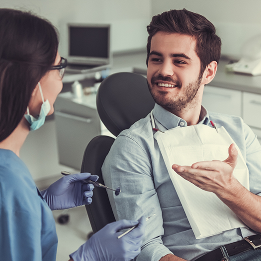 Male dental patient speaking to female dentist