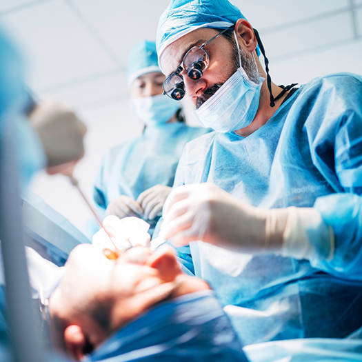 Dentist in mask performing tooth extraction in Fort Smith